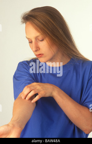 Frau ihren Arm kratzen Stockfoto