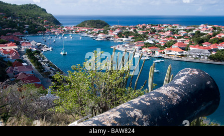 Replik-Kanone in Fort Gustave über rote Blechdach Gebäude im Hafen Stadt Gustavia St Barts Stockfoto