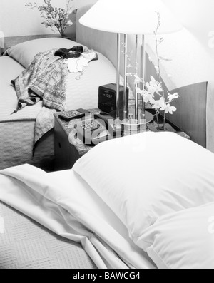 Betten in einem Hotel Zimmer schwarz-weiß Nachttisch Uhr Blumen Ferntelefon Stockfoto