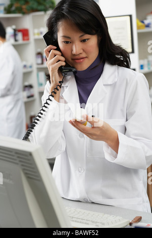 Asiatische Apothekerin am Telefon sprechen Stockfoto