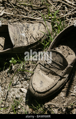ein paar braune Schuhe mit Schlamm im Bereich bedeckt Stockfoto