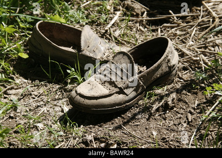 ein paar braune Schuhe mit Schlamm im Bereich bedeckt Stockfoto