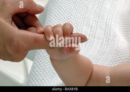 Baby auf weißen Decke mit Müttern finger Stockfoto