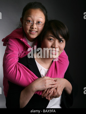 Eine Mutter und Tochter in einer Situation Studion, lächelnd und glücklich. Mutterschaft-Konzept. Stockfoto
