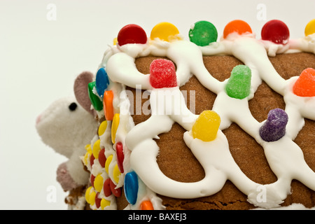 Lebkuchenhaus mit einer Ecke heraus gegessen und eine kleine weiße Maus Höchststand aus dem Augenwinkel Stockfoto