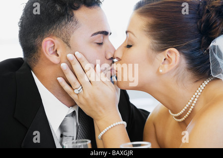 Multi-ethnische Braut und Bräutigam küssen Stockfoto