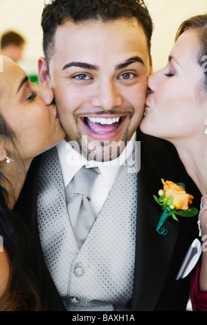 Bräutigam wird von zwei Frauen küssen Stockfoto