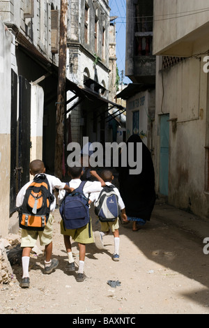 Drei Schuljungen zu Fuß durch die Gasse in der Altstadt, Mombasa, Kenia Stockfoto