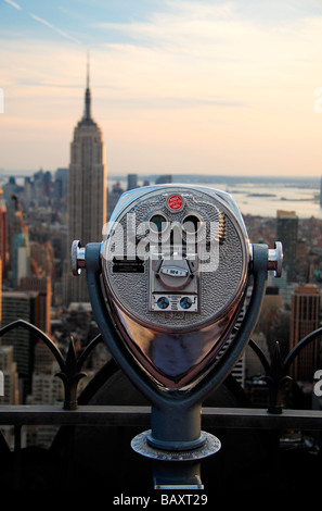 Ein Anzeige-Teleskop auf der Oberseite der Rock-Sternwarte, Rockefeller Center, New York mit Blick auf das Empire State Building Stockfoto