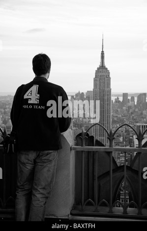 Ein Tourist auf der Spitze der Felsen, Rockefeller Center, New York mit Blick auf das Empire State Building. Stockfoto