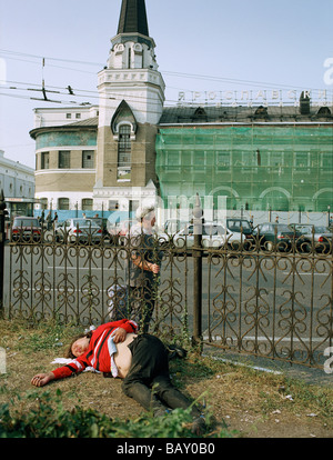 Ein Mann liegt auf dem Boden, im Hintergrund der Jaroslaw-Bahnhof, Moskau, Russland Stockfoto