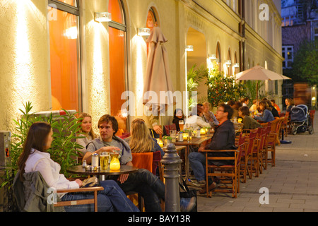 Menschen sitzen vor Cafe Zeitgeist in der Abend, Maxvorstadt, München, Bayern, Deutschland Stockfoto