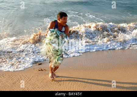 Fischer mit einem Netz voller Fische am Strand von Mazunte, Mexiko Stockfoto