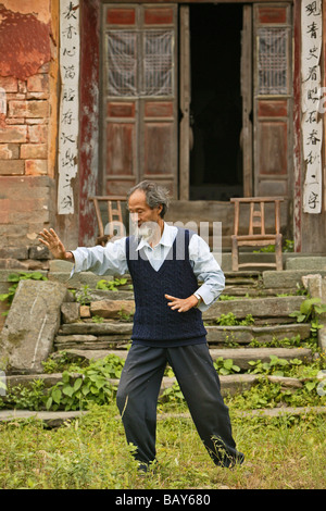 Tai Chi Meister demonstriert Taichi vor seinem alten Haus am Fuße des Mount Wudang, Wudang Shan, taoistische Berg, Hubei pr Stockfoto