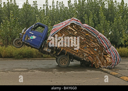 Überladene Dreirad auf einer einsamen Straße, China, Asien Stockfoto