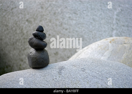 Cairn von schwarzen Kieselsteinen auf weißen Felsen, Tal der Verzasca, Verzascatal, Tessin, Schweiz Stockfoto