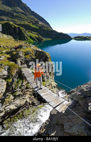 junge Frau auf der Hängebrücke, feste Seil Weg am See Wangenitzsee, Schobergruppe Sortiment, Hohe Tauern Bereich, National Park H Stockfoto