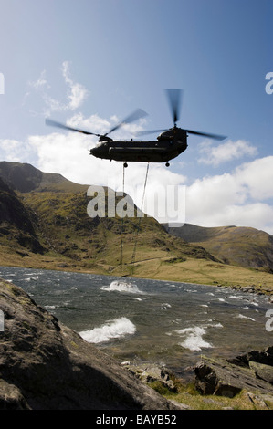 RAF Chinook Helikopter versucht, eine große Schiefertafel Betonplatte auf eine neue Brücke über den Fluss im Llyn Idwal Abfluss fallen Stockfoto