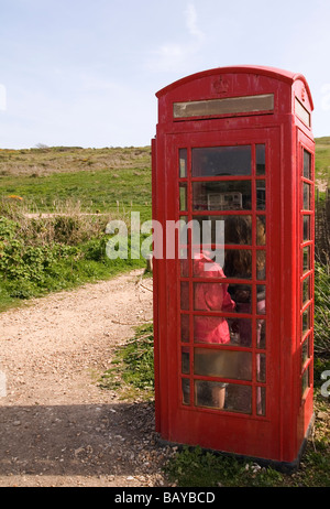 Kinder mitgehen in öffentliche Telefonzelle in Landschaft Stockfoto