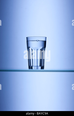 Glas Trinkwasser auf blauem Hintergrund Stockfoto