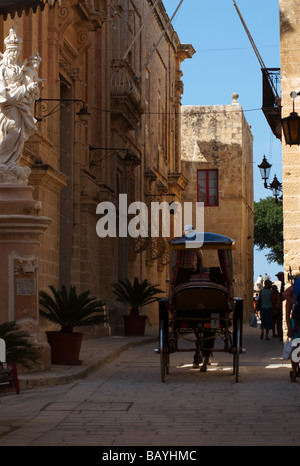 Ein Pferd gezeichneten Buggy bahnt sich ihren Weg durch eine Straße in Mdina, Malta Stockfoto