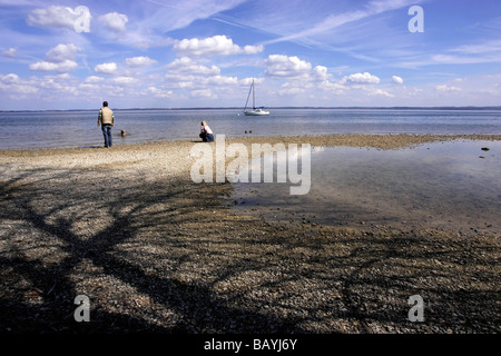 Menschen auf einem Stein Strand Fraueninsel Chiemsee Chiemgau Bayern Deutschland, Europa Stockfoto