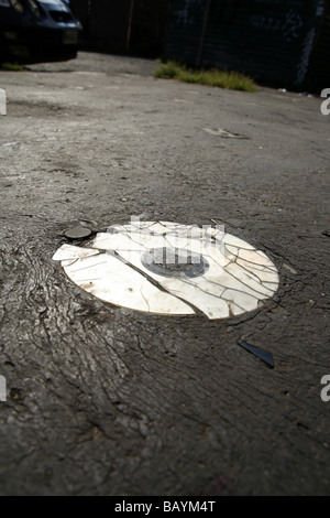 eine alte beschädigte cd Compcat Disk auf Fahrbahn Stockfoto