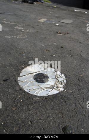 eine alte beschädigte cd Compcat Disk auf Fahrbahn Stockfoto