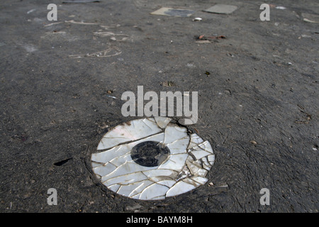 eine alte beschädigte cd Compcat Disk auf Fahrbahn Stockfoto