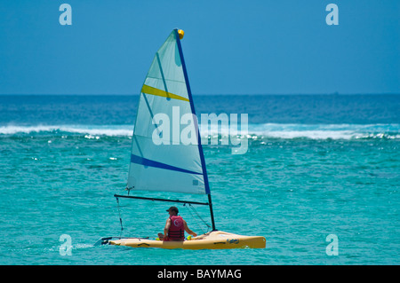 Mann in einem gelben Segelboot segeln, am Indischen Ozean in der Nähe von Strand von Mauritius, horizontale Stockfoto