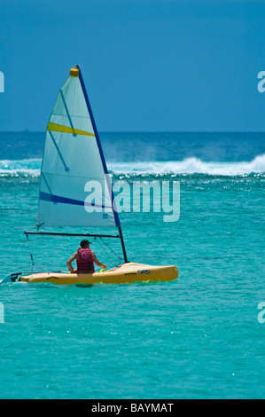 Mann in einem gelben Segelboot segeln, am Indischen Ozean in der Nähe von Strand von Mauritius, horizontale Stockfoto