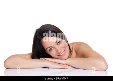 Beautiful brunette woman lying with her face on her hands isolated on white background Stockfoto