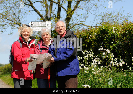 Gruppe von Wanderern Pause, um ihre Karte zu lesen und überprüfen die Fahrtrichtung gesehen in der Hampshire-Landschaft im Frühling Stockfoto