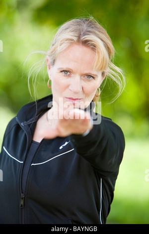 Ein weiblicher Yoga-Lehrer während einer Outdoor-Klasse in der englischen Landschaft Stockfoto