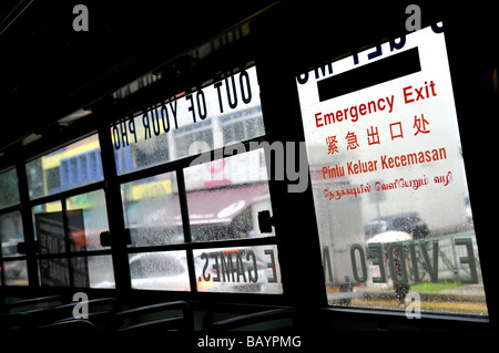 Multi-Lingual "Notausgang" Anmelden Fenster von öffentlichen Verkehrsmitteln Bus, Singapur Stockfoto