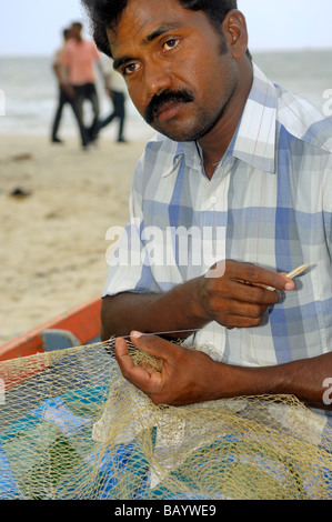 Fischer Reparatur Fischernetz am Strand Maraikulam Beach an der Malabar-Küste Kerala Indien Stockfoto