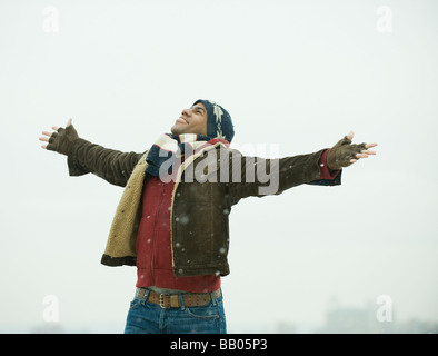 Afrikanische amerikanische Mann im Schnee mit ausgestreckten Armen Stockfoto