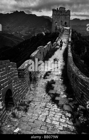 Ein Wanderer Spaziergänge entlang einem unrestaurierten Abschnitt der großen Mauer in der Nähe von Simatai, 160km nördlich von Peking, Volksrepublik China. Stockfoto