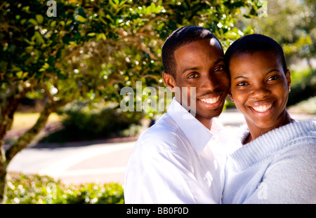 Black African American Paar glücklich zusammen im Sonnenschein zu Hause im Hof zusammen und kuscheln Stockfoto