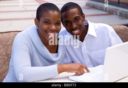 Black African American Paar gemeinsam auf Computer im Freien im Geschäft Stockfoto