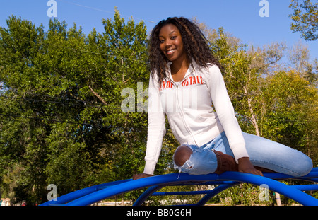 Black African American Woman Portrait auf Balken Klettern im Outdoorpark lächelnd Stockfoto