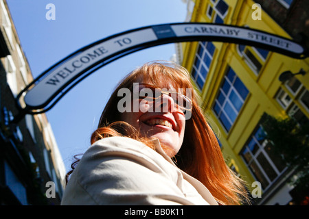 Frau mit roten Haaren auf der Carnaby Street London. Stockfoto