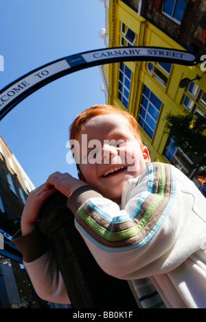 Fünf Jahre alten Jungen auf der Carnaby Street, London, die Sonne zu genießen. Stockfoto