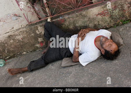 Ein Obdachloser Mann liegt auf dem Bürgersteig in der Jungke Stadt Manaus Brasilien der Mann geschlagen gequetscht shoeless krank Destitude Stockfoto