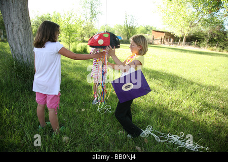 Mädchen im Alter von acht Jahren ein Marienkäfer Pinata zu bewundern ist-Geburtstags-party Stockfoto