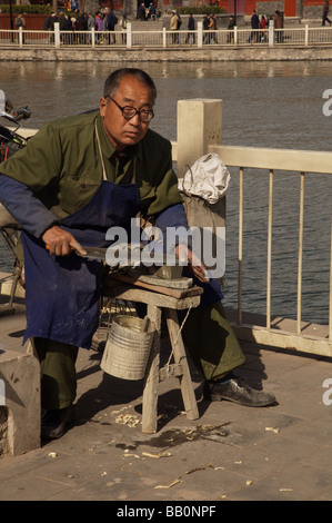 Schärfen der Messer auf Straße in Peking China Mann Stockfoto