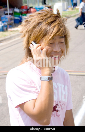 Asiatische Hmong jugendlich mit Hip-Hop Frisur reden über Handy. Hmong Sport Festival McMurray Feld St Paul Minnesota USA Stockfoto