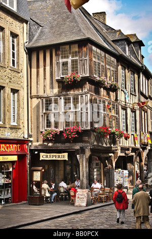 Straßenszene in Dinan, Frankreich. Mittelalterliche Repräsentationsarchitektur mit Gebäuden überhängenden Street und Creperie. Tourist erschossen Stockfoto