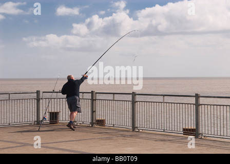 Ein Mann Angeln aus dem Ende des Southwold Pier in Southwold, Suffolk, Uk Stockfoto