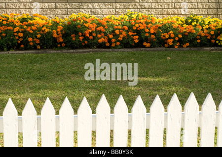 weißen Lattenzaun mit Blumenbeet Stockfoto